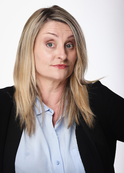 Sue Collins, eyebrow raised, in a black blazer and pale blue shirt